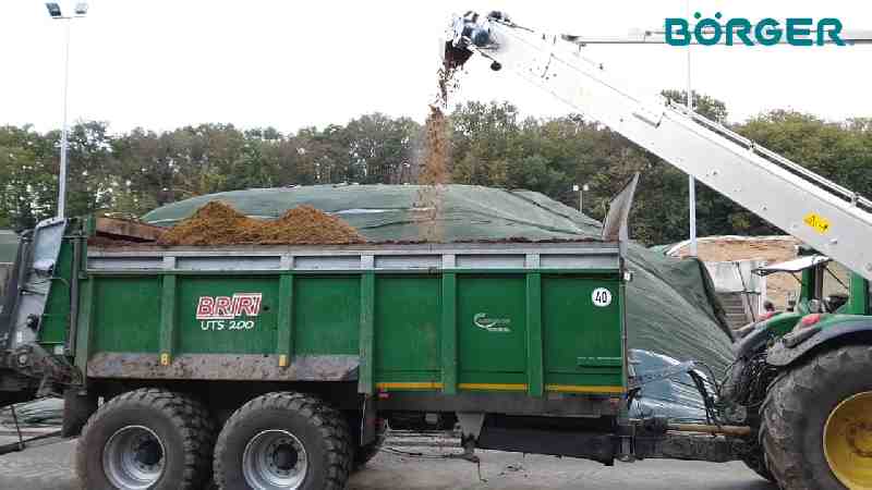 A conveyor discharging Dewatered digestate produced in a Borger Digestate Separator Trailer. falls into a digestate separation trailer. 